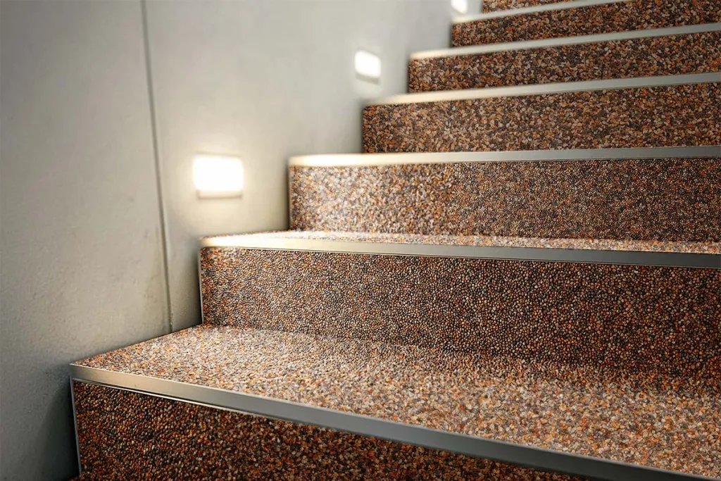 Steinteppich Treppe mit roter Körnung und Kantenschutz